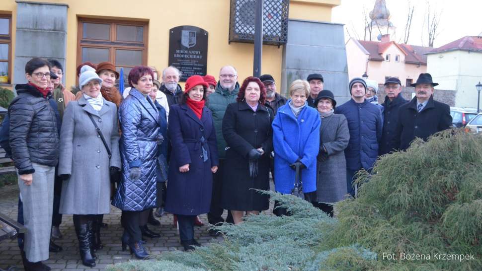 Zdjęcie grupowe pod tablicą Mikołaja Brodeckiego - założyciela miasta 13.02.2022 r.
